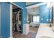 Bathroom view into bedroom; features blue accent wall, closet, vanity and sink at 623 White Ash Trl, Mooresville, IN 46158