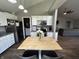 Functional kitchen with a wood island, stainless steel appliances, white cabinetry, and open access to living room at 623 White Ash Trl, Mooresville, IN 46158