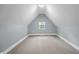 Well-lit attic space with neutral walls and carpet, offering potential for a cozy bonus room at 629 N Keystone Ave, Indianapolis, IN 46201