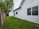 Green backyard area along the side of a white home, with grass and partial fencing at 629 N Keystone Ave, Indianapolis, IN 46201