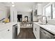 Modern kitchen with stainless steel appliances, white cabinets, and a view into the dining room at 629 N Keystone Ave, Indianapolis, IN 46201