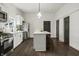 Modern kitchen with stainless steel appliances, a central island, and elegant dark-colored doors at 629 N Keystone Ave, Indianapolis, IN 46201