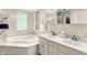 This is a large bathroom with a soaking tub, a double vanity, and a glass block window at 6440 Saint Joe Dr, Indianapolis, IN 46217