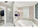 This is a large bathroom with a soaking tub, a glass block window, and a glass shower door at 6440 Saint Joe Dr, Indianapolis, IN 46217