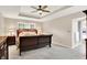 Main bedroom with a large bed, ceiling fan, carpet, and adjacent bathroom at 6440 Saint Joe Dr, Indianapolis, IN 46217