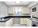 This laundry room includes white cabinets and drawers, black granite countertops, and a stainless steel washer/dryer at 6440 Saint Joe Dr, Indianapolis, IN 46217