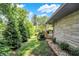 Landscaped yard featuring mature trees and a stone wall at 6440 Saint Joe Dr, Indianapolis, IN 46217
