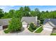 An expansive aerial view shows a charming single-story home nestled among lush trees and manicured lawns at 65 Palomino Ct, Zionsville, IN 46077