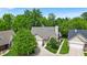 A serene aerial view captures a charming single-story home nestled among lush trees and manicured lawns at 65 Palomino Ct, Zionsville, IN 46077