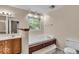 Bathroom with soaking tub, tiled floors, and wooden cabinets at 65 Palomino Ct, Zionsville, IN 46077