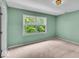 A bright bedroom with green walls, carpet and natural light from the large window at 65 Palomino Ct, Zionsville, IN 46077