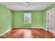 Green bedroom with hard wood floors and a window view to the backyard at 65 Palomino Ct, Zionsville, IN 46077