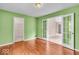 This bedroom features green walls, wood floors, and bright, natural light at 65 Palomino Ct, Zionsville, IN 46077