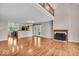 Bright, open living space featuring gleaming hardwood floors, a cozy fireplace, and views into the kitchen area at 65 Palomino Ct, Zionsville, IN 46077