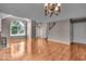 An open living room featuring gleaming hardwood floors, a cozy fireplace, a large window, and a staircase at 65 Palomino Ct, Zionsville, IN 46077