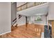 Expansive living area with gleaming hardwood floors, a fireplace, staircase, and views into kitchen area with breakfast bar at 65 Palomino Ct, Zionsville, IN 46077