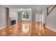 Bright living room with gleaming hardwood floors, a cozy fireplace, a large window, and a white front door at 65 Palomino Ct, Zionsville, IN 46077