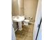 Small bathroom featuring a pedestal sink, toilet, mirror, and tile flooring at 6634 Frankenberger Dr, Indianapolis, IN 46237