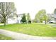 Charming home with a large front yard, mature trees, and a welcoming front porch swing at 6634 Frankenberger Dr, Indianapolis, IN 46237