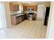 Spacious kitchen boasts stainless steel appliances, brown cabinets, tile floors and natural light at 6634 Frankenberger Dr, Indianapolis, IN 46237