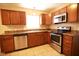 Cozy kitchen with stainless steel appliances, brown cabinetry, laminate countertops, and tile flooring at 6634 Frankenberger Dr, Indianapolis, IN 46237