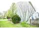 Manicured yard with lush green grass and mature trees lining the house at 6634 Frankenberger Dr, Indianapolis, IN 46237
