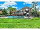 View of backyard pool with slide, patio, and well-maintained lawn, surrounded by a black metal fence at 676 La Placita St, Greenwood, IN 46143