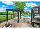 Backyard oasis with a pergola, pool with diving board, and a slide, set in landscaped gardens at 676 La Placita St, Greenwood, IN 46143