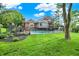 Backyard view of large pool and well-manicured lawn with large trees providing ample shade at 676 La Placita St, Greenwood, IN 46143