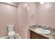 Powder room featuring a vanity with a granite counter, decorative backsplash, and white toilet at 676 La Placita St, Greenwood, IN 46143