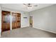 Neutral bedroom with carpet, ceiling fan, wooden closet door, and door leading to another room at 676 La Placita St, Greenwood, IN 46143