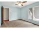 Light blue bedroom with neutral carpet, large windows, and ceiling fan at 676 La Placita St, Greenwood, IN 46143