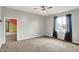 Spacious light-grey bedroom with neutral carpet, ceiling fan, and large window at 676 La Placita St, Greenwood, IN 46143