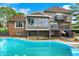 Exterior showcasing a backyard pool, elevated deck, walkout basement and brick and siding finishes at 676 La Placita St, Greenwood, IN 46143