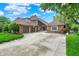 Expansive brick home with attached garage, a long driveway, and lush landscaping at 676 La Placita St, Greenwood, IN 46143
