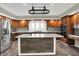 Well-lit kitchen with stainless appliances, wood cabinets, granite countertops, and large center island at 676 La Placita St, Greenwood, IN 46143