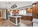 Inviting kitchen with wood cabinets, granite countertops, stainless steel appliances, and a center island cooktop at 676 La Placita St, Greenwood, IN 46143