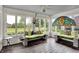 Stylish sunroom with decorative seating and windows galore overlooks expansive green space and landscaping at 676 La Placita St, Greenwood, IN 46143
