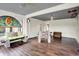 Bright sunroom showcases unique seating arrangements, wood floors, and decorative stained-glass at 676 La Placita St, Greenwood, IN 46143
