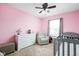Charming bedroom features a crib, armchair, and dresser; all in a pink color scheme at 6842 Viola Ct, Indianapolis, IN 46237