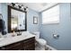 Stylish half-bathroom featuring a modern vanity, toilet, and a charming blue wall that exudes comfort and appeal at 6842 Viola Ct, Indianapolis, IN 46237