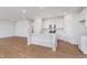 Bright kitchen with stainless steel appliances, white cabinets, island and wood flooring at 6871 Seabiscuit Rd, Whitestown, IN 46075