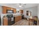 Well-lit kitchen with stainless steel appliances, wood cabinets, plank floors, and a dining table at 70 Casco Dr, Avon, IN 46123