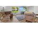 Inviting living room with plush seating, gray rug, wood laminate floors, and beach scene on the TV at 70 Casco Dr, Avon, IN 46123