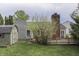 Large backyard features a shed, mature trees, and a deck with a brick chimney at 7053 Colita More Nw Ct, Indianapolis, IN 46254