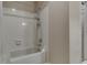 Bathtub and shower combo with multi-setting shower head and white tiled walls at 7053 Colita More Nw Ct, Indianapolis, IN 46254