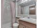 Clean bathroom with shower curtain, single sink vanity, marble counter and floral wallpaper border at 7053 Colita More Nw Ct, Indianapolis, IN 46254