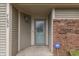 Home featuring a covered front porch, an ornate glass door, and decorative brick accents at 7053 Colita More Nw Ct, Indianapolis, IN 46254