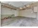 Spacious garage with concrete floor, a mower, and overhead door at 7053 Colita More Nw Ct, Indianapolis, IN 46254