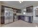 Well-lit kitchen featuring stainless steel appliances, dark wood cabinets and stone backsplash at 7053 Colita More Nw Ct, Indianapolis, IN 46254